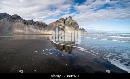 vestrahorn im Süden Islands, Spiegelung in ruhigem Wasser über schwarzem vulkanischen Strand, Landschaftsfotografie Stockfoto