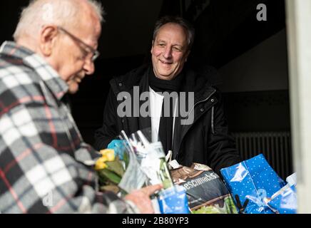 Berlin, Deutschland. März 2020. Christian Stäblein (r), Bischof der Evangelischen Kirche Berlin-Brandenburg-schlesische Oberlausitz, hilft an der Passionskirche bei der Verteilung von Lebensmitteln für Bedürftige. Die Berliner Tafel versucht mit einem Krisenplan, die Unterstützung für Bedürftige während der Coronavirus-Pandemie fortzusetzen. Credit: Fabian Sommer / dpa / Alamy Live News Stockfoto