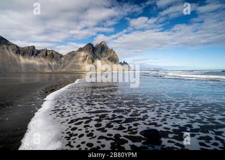 vestrahorn im Süden Islands, Spiegelung in ruhigem Wasser über schwarzem vulkanischen Strand, Landschaftsfotografie Stockfoto