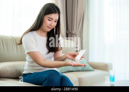 Asiatische Frauen, die Lotion oder Feuchtigkeit als Hand ihres täglichen Lebens verwenden, um die Haut zu trocknen und zu reizen, nachdem sie alkoholantiseptisches Gel verwendet haben, Stockfoto