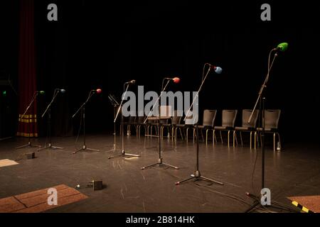 Mikrofone, die vor einer Live-Radio-Vorstellung auf einer leeren Theaterbühne aufgereiht waren. Stockfoto