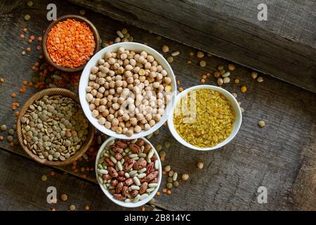 Ernährung und gesundes Esskonzept, vegane Proteinquelle. Rohstoff von Hülsenfrüchten (Kichererbsen, rote Linsen, kanadische Linsen, Bohnen, Bulgur). Draufsicht auf eine flache La Stockfoto