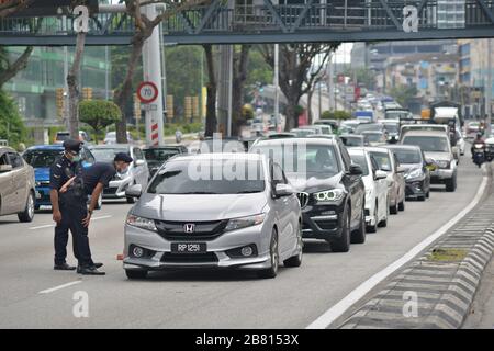 Kuala Lumpur, Malaysia. März 2020. Polizeibeamte, die Masken tragen, überprüfen Fahrzeuge in Kuala Lumpur, Malaysia, 19. März 2020. Malaysia kündigte am Donnerstag 110 neue bestätigte Fälle von COVID-19 an und brachte die Gesamtzahl der Fälle auf 900, sagte das Gesundheitsministerium. Credit: Chong Voon Chung/Xinhua/Alamy Live News Stockfoto