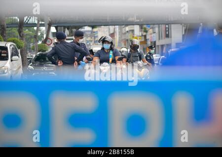 Kuala Lumpur, Malaysia. März 2020. Polizeibeamte, die Masken tragen, überprüfen Fahrzeuge in Kuala Lumpur, Malaysia, 19. März 2020. Malaysia kündigte am Donnerstag 110 neue bestätigte Fälle von COVID-19 an und brachte die Gesamtzahl der Fälle auf 900, sagte das Gesundheitsministerium. Credit: Chong Voon Chung/Xinhua/Alamy Live News Stockfoto