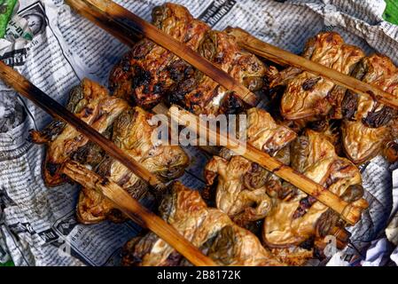 Frittierte Grünfrösche auf Stöcken. Eine traditionelle Delikatesse, die auf dem Maeklong Eisenbahnschienen Market, Bangkok, Thailand, zu finden ist Stockfoto