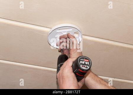 Rauchmelder an einer Decke, Installation eines Rauchmelders an einer Decke in Berlin Stockfoto