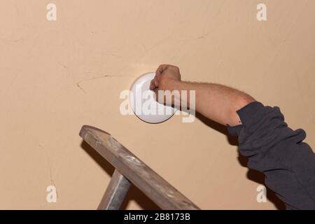 Rauchmelder an einer Decke, Installation eines Rauchmelders an einer Decke in Berlin Stockfoto