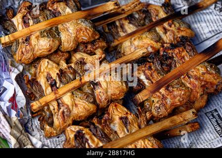 Frittierte Grünfrösche auf Stöcken. Eine traditionelle Delikatesse, die auf dem Maeklong Eisenbahnschienen Market, Bangkok, Thailand, zu finden ist Stockfoto
