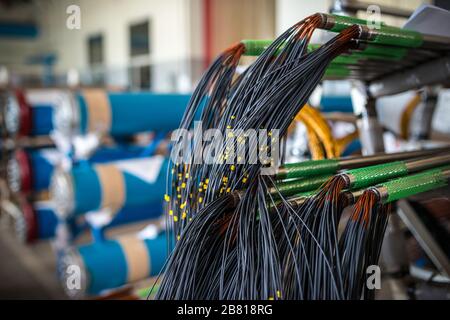 Drahtbündel hängt bei der Herstellung von Elektronikteilen für große Werksstrukturen von Leitungen. Konzept Fertigung von Industrieteilen Stockfoto