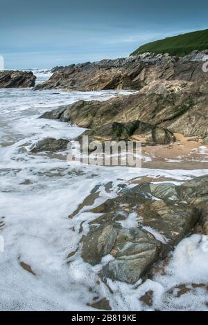 Die Flut, die in Newquay in Cornwall um die Felsen wirbelt, wirbelt. Stockfoto