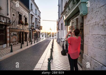 Touristen fotografieren in einer schmalen Straße und Geschäften im Stadtzentrum von Amboise, Loire-Tal, Frankreich Stockfoto