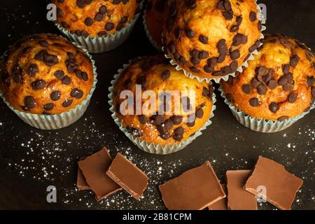 Cupcakes mit Schokoladenchips auf einem dunklen Tisch Stockfoto