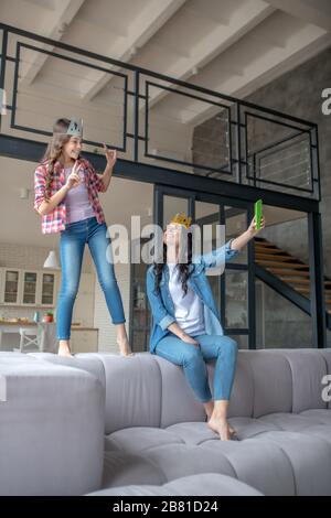 Mutter und Tochter tragen Kronen und haben gute Zeit Stockfoto