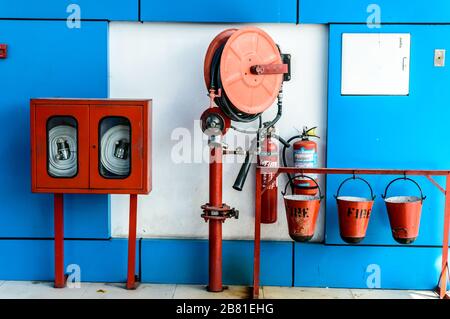 Wandaufhängender Feuerlöscher, Brandsicherheit und Notfallausrüstung in der Wandmontage des Red Blue Box Architekturfeuerlöschers Glasschrank i Stockfoto
