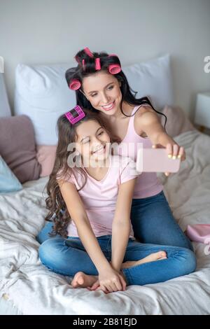 Mutter und Tochter mit Haarkräuseln machen selfie Stockfoto