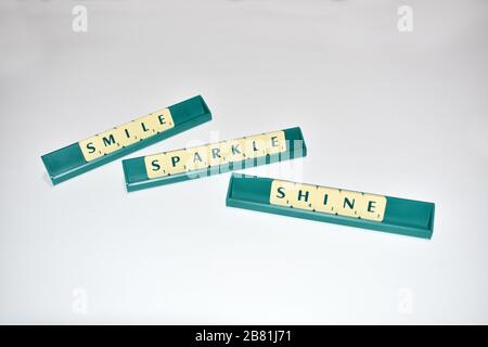 Scrabble Fliesen schreiben Smile Sparkle Shine Motivationszitat Scrabble Blocks Letters Grey Background Life Quote induzieren Alphabet. Stockfoto