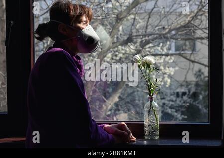 Eine selbstisolierte Frau oder eine Quarantäne, die auf Window Home blickt Stockfoto