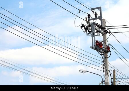 Elektrische Pol-Stromzangenkabel Gefahr, elektrische Energie auf Straße auf Himmelshintergrund verdrahten Stockfoto