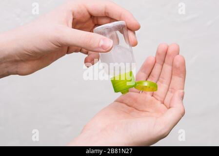 Handantiseptikum. Mädchen drückt Sanddesinfektionsmittel aus einer Flasche auf die Hände. Kleine antibakterielle Handdesinfektionsmittel. Stockfoto