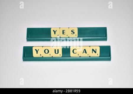 Scrabble Kacheln buchstabieren Ja Sie können motivierendes Zitat Scrabble Blocks Letters Grauer Hintergrund Lebenszitat induzieren Alphabet. Stockfoto