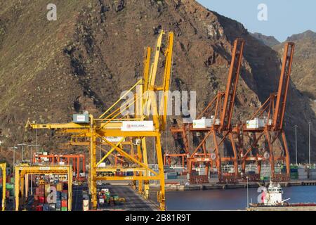 Kräne und Transportcontainer auf der Dockseite in Santa Cruz, auf der Insel Tenera mit Bergen im Hintergrund Stockfoto