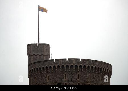 Die Flagge der Royal Standard, die über Schloss Windsor fliegt, während Königin Elisabeth II. Im Schloss Windsor ankommt, vom Buckingham Palace in London, um sich in sozialer Hinsicht inmitten der Coronavirus Pandemie zu distanzieren. Stockfoto