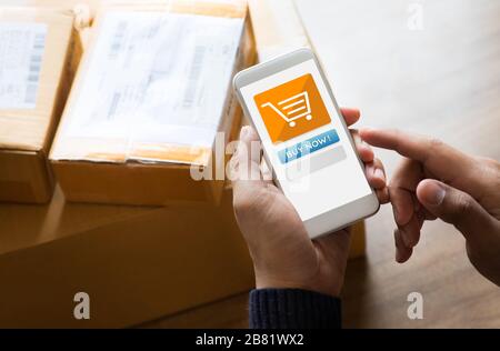 Online-Shopping-Konzepte mit jungen Menschen, die Smartphone für die Bezahlung verwenden, seine Bestellung auf einer Vielzahl von Produktpaketen Box.E Commerce Market.Business Retail.mo Stockfoto