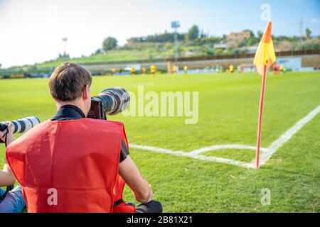 Fotoreporter mit Teleobjektiv auf einem Fußballspiel Stockfoto