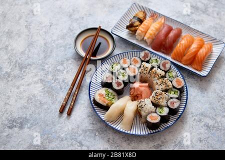 Asiatische Lebensmittel Sortiment. Verschiedene sushi Rollen auf keramischen Platten platziert Stockfoto