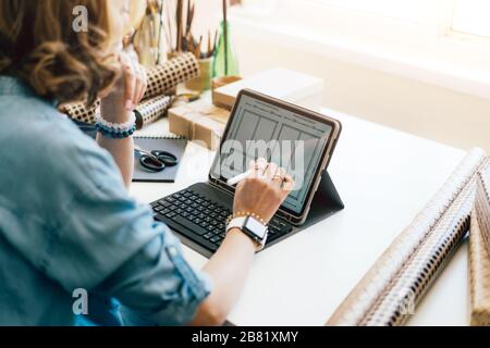 Der Creative Manager zeichnet ein Design auf einem Bildschirm auf einem Laptop. Stockfoto