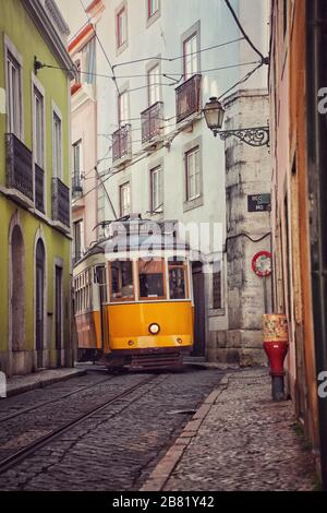 Alte Straßenbahn in einer schmalen Straße von Lissabon, Portugal Stockfoto