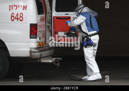 (200319) -- TEL AVIV, 19. März 2020 (Xinhua) -- Ein Mitarbeiter von Magen David Adom, der nationalen Rettungsorganisation Israels, desinfiziert einen Krankenwagen als präventive Maßnahme gegen das neuartige Coronavirus außerhalb des Dan-Hotels, das für den Empfang von COVID-19-Patienten umgewandelt wird, in der zentralisraelischen Stadt Tel Aviv am 18. März 2020. (Gideon Markowicz/JINI/Handout über Xinhua) Stockfoto