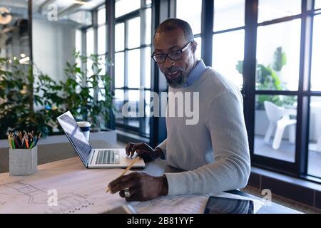 Afroamerikanischer Mann, der im modernen Büro arbeitet Stockfoto