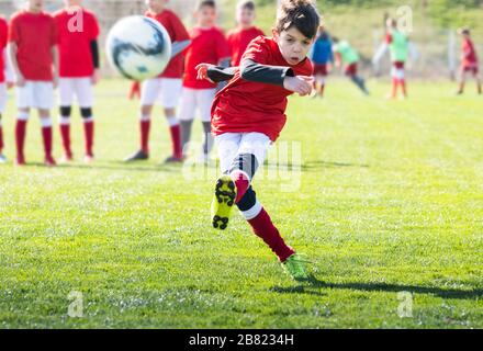 Jungs spielen Fußball auf dem Feld Stockfoto