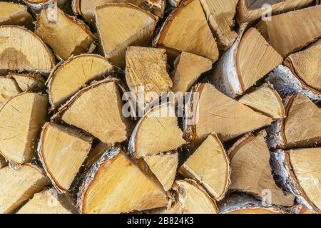 holzstämme übereinander gestapelt. Wand aus gestapelten Holzstämmen als Hintergrund. Stapel von Holzstämmen. Brennholzstapel in Nahaufnahme. Protokolle schneiden im Voraus ab Stockfoto