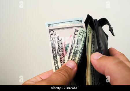 In den Händen eines Geldbeutels, in dem der amerikanische Dollar einrechnet Stockfoto