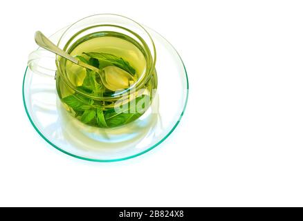 Minztee in einer gläsernen, transparenten Tasse auf einer Untertasse Stockfoto