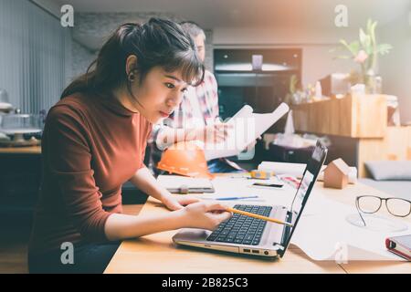 Gruppe von zwei Mitarbeitern, die mit Blueprint im Büro arbeiten. Gemeinsames Teamwork-Konzept. Stockfoto