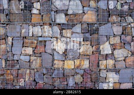Wand aus Steinen hinter dem Gitter Stockfoto