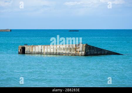 Weltkrieg zwei Tage lang versteinern der Mulberry-Hafen-Beton Reste im Meer, Arromanches-les-Bains, Normandie, Frankreich. Stockfoto