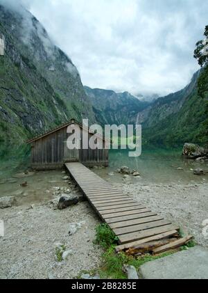 Holzhütte/Bootshaus am Obersee, umgeben von Bergen in Schönau am Koenigssee in den bayerischen Alpen, Nationalpark Berchtesgaden, Deutschland Stockfoto