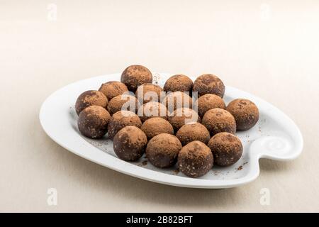 Vegane Schokoladentrüffel mit Nüssen und Samen auf weißem Grund Stockfoto