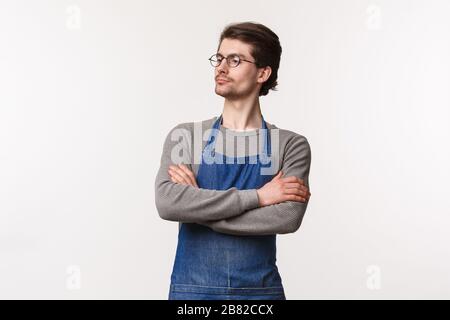 Taillen-Up-Portrait eines ernsthaft aussehenden, entschlossenen männlichen Restaurantmanagers, der Mitarbeiter betrachtet, die Arbeit kontrolliert, die Hände über die Brust wie professionell übergeht Stockfoto