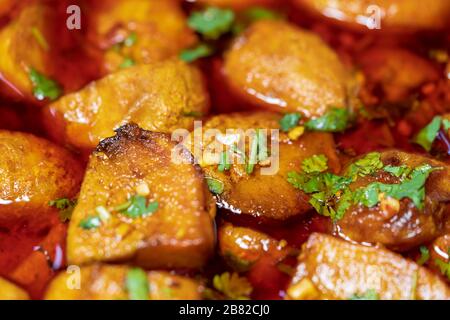 Dum Aloo - indische vegetarische Speise mit Kartoffeln, langsam in Tomatenzwiebel gekocht, rote Chilischote in der Soße. Flacher Laienschienenschuss. Konzept für indische Cuis Stockfoto
