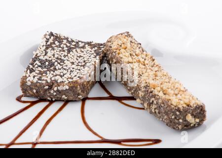 Veganer Schokoladenkuchen mit Nüssen und Samen auf weißem Hintergrund Stockfoto