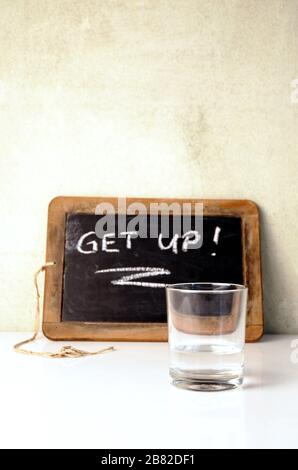 Kelch- und Wasserglas mit dem Motivationstext erwachen Stockfoto
