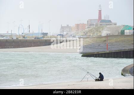 Den Haag, Südholland/Niederlande - 200222: Fischer im Fischfang an einem Strand in der Nähe des Scheveninger Hafengeländes. Stockfoto