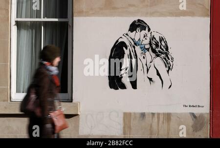 Ein Kunstwerk des Künstlers, bekannt als Rebel Bear, ist an einer Wand in der Bank Street in Glasgow aufgetaucht. Die neue Ergänzung zu Glasgows Straßenkunst erfasst die globale Coronavirus Krise. Das Stück zeigt eine Frau und einen Mann, der sich zurückzieht, um sich gegenseitig einen Kuss zu geben. Stockfoto