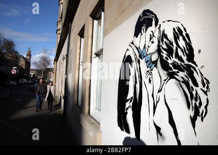 Ein Kunstwerk des Künstlers, bekannt als Rebel Bear, ist an einer Wand in der Bank Street in Glasgow aufgetaucht. Die neue Ergänzung zu Glasgows Straßenkunst erfasst die globale Coronavirus Krise. Das Stück zeigt eine Frau und einen Mann, der sich zurückzieht, um sich gegenseitig einen Kuss zu geben. Stockfoto