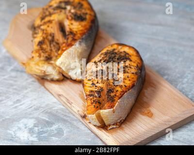 Steaks für Ofenlachs. Zwei rote Scheiben roter Fisch mit Gewürzen. Zu Hause gekochter Fisch zum Abendessen Stockfoto